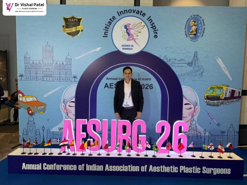 Dr. Vishal Patel standing near AESURG 2026 signage in Mumbai