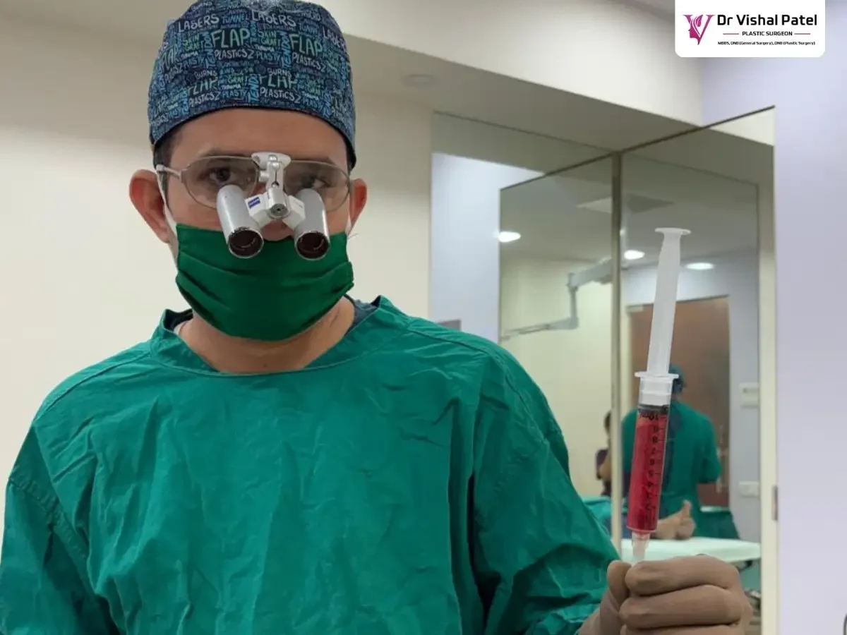 Dr. Vishal Patel holding breast enlargement injection in one hand.