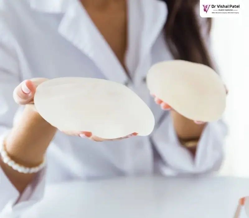 Women holding breast implants in her hands.