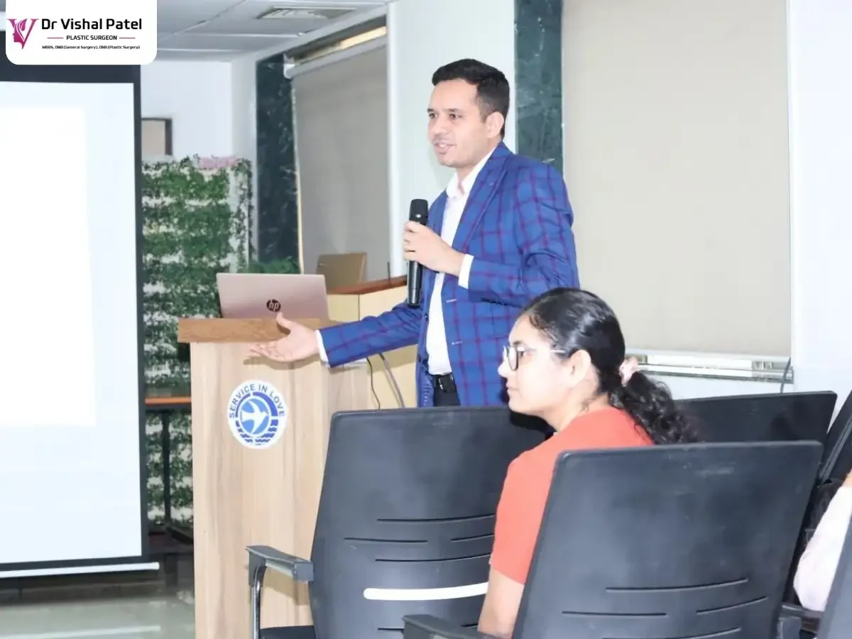 Dr. Vishal Patel holding mic in a seminar hall.