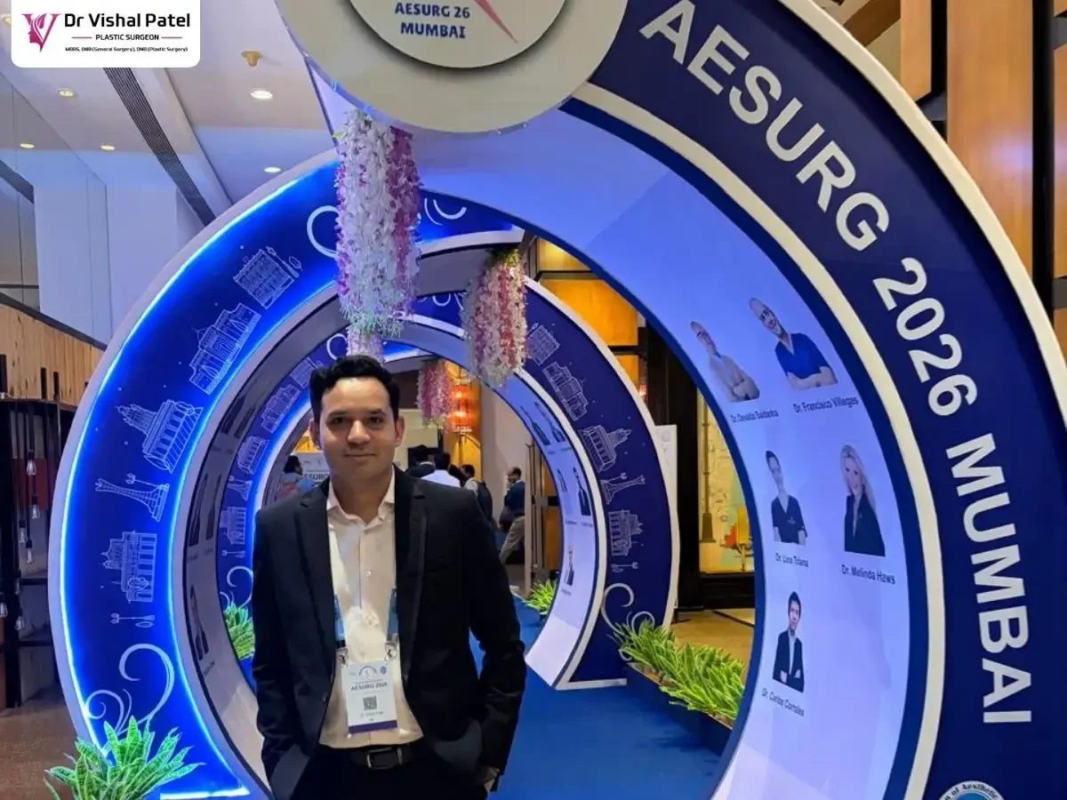 Dr. Vishal Patel with AESURG 2026 signage in back.