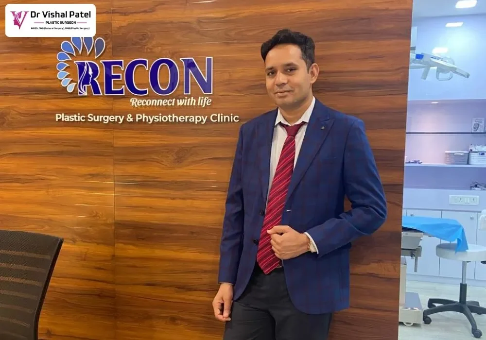 Dr. Vishal Patel standing at Reception at his clinic with Recon Clinic Signage at back.
